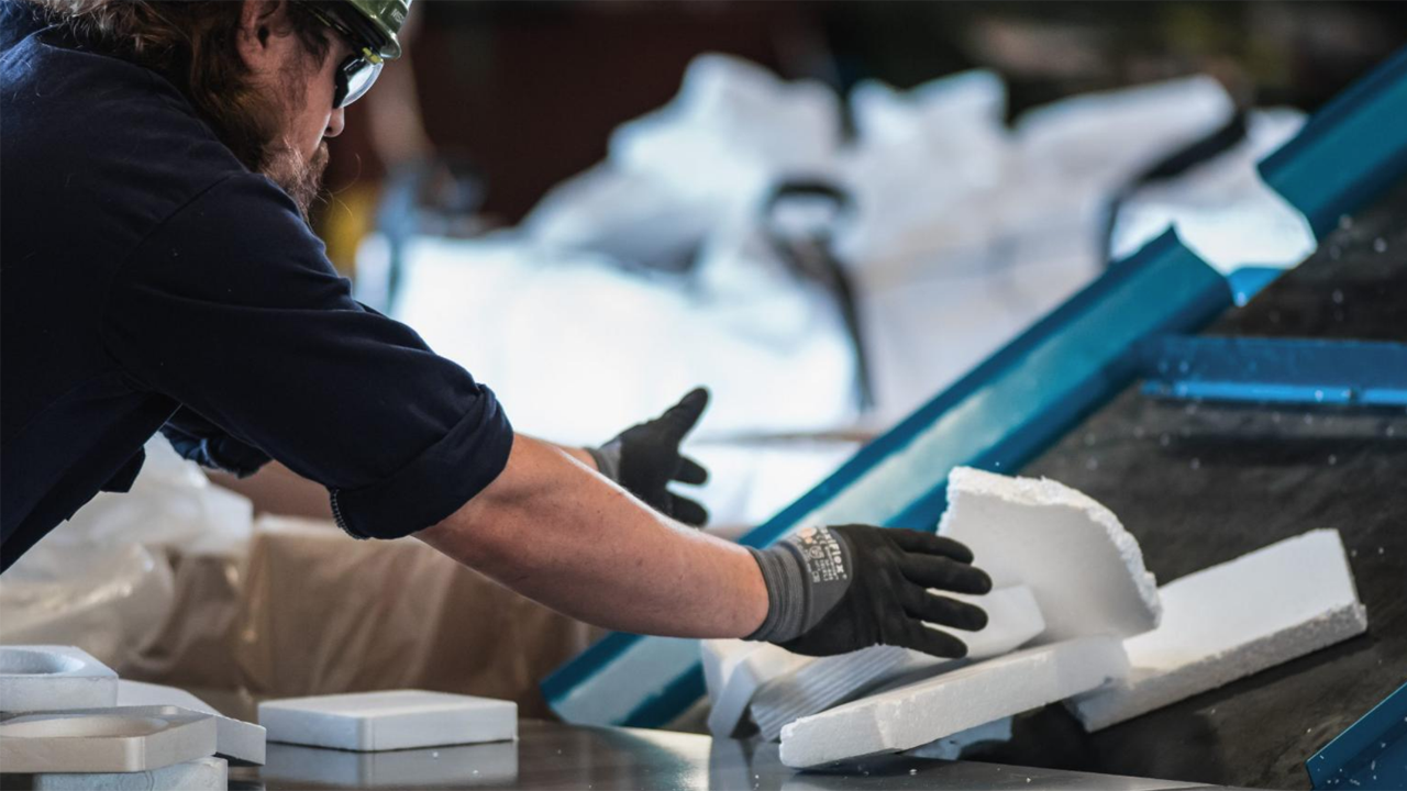 A Cyclyx employee feeds post-use polystyrene onto a conveyer belt to shred and prepare it for the chemical recycling process. (Photograph and Caption Courtesy of UP)
