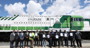 FRA Administrator Amit Bose, Anacostia Rail Holdings executives, and ports of Los Angeles and Long Beach officials on May 4 gathered to celebrate PHL’s latest group of locomotive engineer graduates to serve the San Pedro Port complex. They stand in front of Progress Rail’s zero-emission, zero-idle EMD® Joule battery-electric locomotive, which recently arrived to begin a year of railroad testing. (Photograph Courtesy of The Wolcott Group)