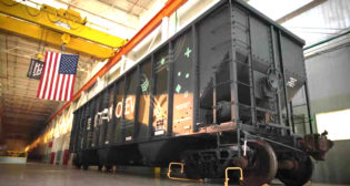 According to Intramotev, its ReVolt cars remain in the train consist “to capture energy via regenerative braking and reduce locomotives’ diesel consumption,” while its TugVolt cars (pictured)—supplied as a “proprietary kit that can retrofit/upfit existing railcars to become battery-electric”—can decouple from the consist to independently provide first- and last-mile service.