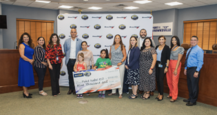 BRG’s $9,000 donation to Point Isabel Independent School District in honor of nine “safe” shipper will provide clothing and school supplies for local students and families impacted by Laguna Heights tornado, according to OmniTRAX. BRG President Shariff Gonnella, pictured fourth from left; Norma Torres, retired BRG leader, pictured sixth from right. (Photograph Courtesy of OmniTRAX)