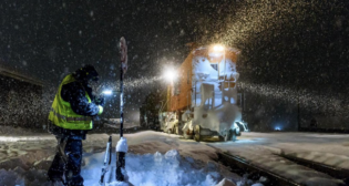 In the midst of a heavy snowfall, a brakeman lines a switch In Truckee, Calif. (Caption and Photograph Courtesy of UP)