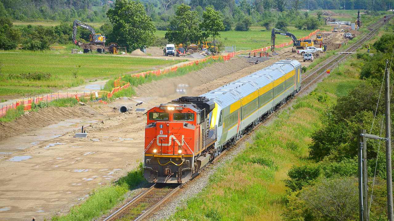 A CN train is viewed passing the Milton Intermodal Terminal construction site in July 2023 as crews work to extend the 