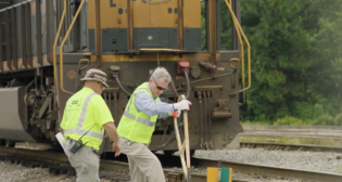 CSX educated Rep. Buddy Carter (R-Ga.) on what it’s like to be a railroader during his visit to the Southover Yard in Savannah, Ga.—including how to throw a switch. Carter is pictured (right) with CSX Conductor Kevin Cook. (Screen Shot of CSX Video)