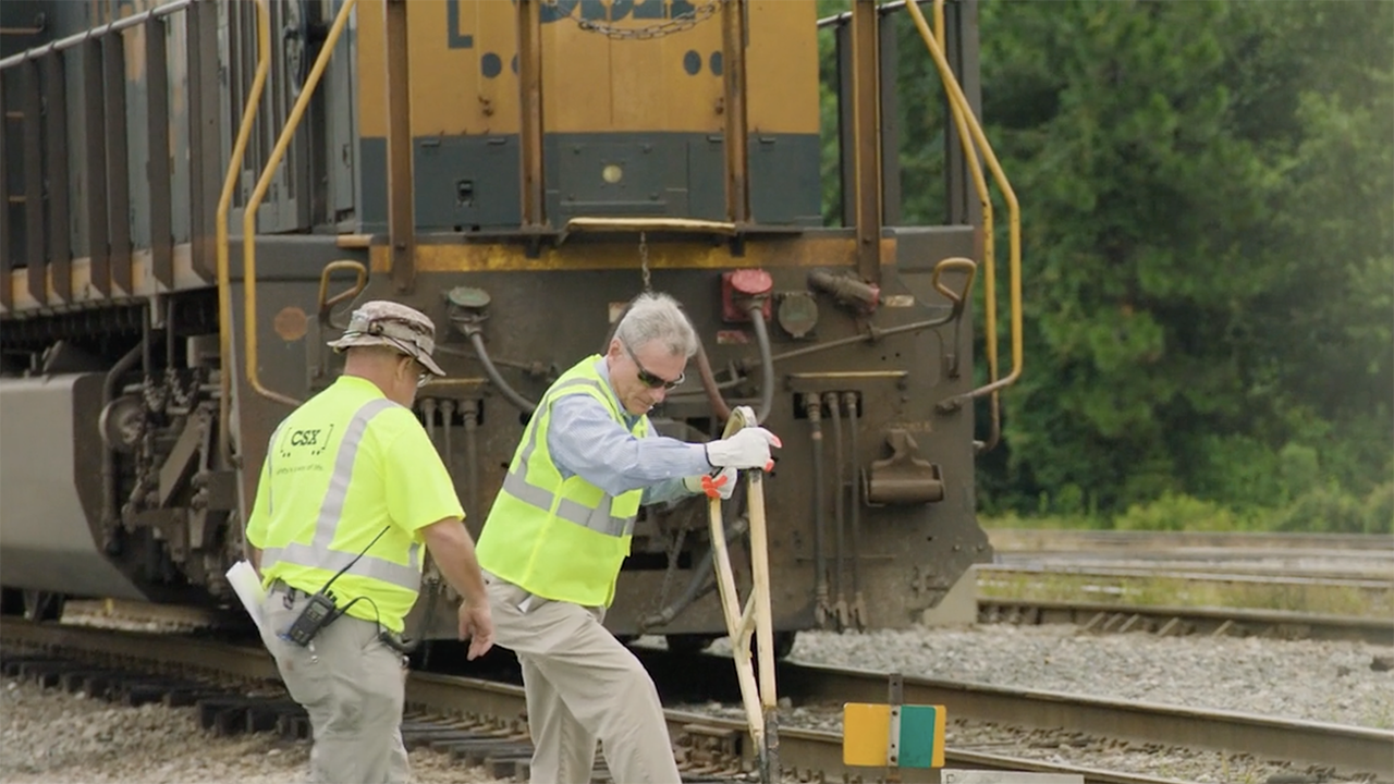 CSX educated Rep. Buddy Carter (R-Ga.) on what it’s like to be a railroader during his visit to the Southover Yard in Savannah, Ga.—including how to throw a switch. Carter is pictured (right) with CSX Conductor Kevin Cook. (Screen Shot of CSX Video)