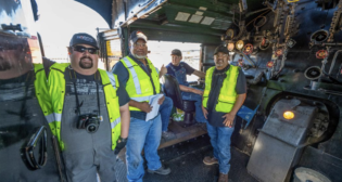UP craft professionals Ronald Chapman, far left, and Joe Montiel, far right, rode in the cab of No. 4014 on Aug. 28. (Caption and Photograph Courtesy of UP)