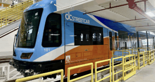 OCTA Board members and local elected leaders on May 7 previewed the first OC Streetcar vehicle in Santa Ana, Calif. Some additional work, including installing bumpers, needs to be completed before testing begins along the former Pacific Electric right of way in a few weeks. (Caption details and photograph courtesy of OCTA)