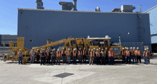 UP’s team of mechanics stands with the 100th rebuilt tamper at its Denver, Colo., shop. The railroad’s maintenance-of-way equipment fleet helps to maintain more than 18,000 miles of track and to compact 4 million tons of ballast each year. (UP Photograph)
