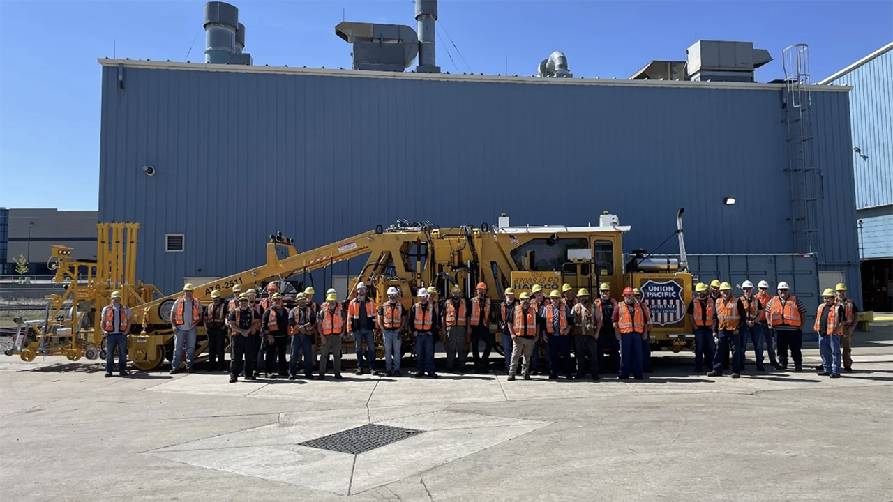 UP’s team of mechanics stands with the 100th rebuilt tamper at its Denver, Colo., shop. The railroad’s maintenance-of-way equipment fleet helps to maintain more than 18,000 miles of track and to compact 4 million tons of ballast each year. (UP Photograph)