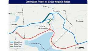 The graphic shows the map of the route for the future bypass at Lac-Mégantic, which will go through the municipalities of Nantes, Lac-Mégantic, and Frontenac. The blue line shows the chosen route; the red line shows the route of the existing track which will be dismantled following the commissioning of the bypass; and the green line shows the sector of the Lac-Mégantic industrial park where car triage and storage activities will take place. (Map and caption courtesy of the government of Canada)