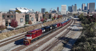 NS Train 955 passing through downtown Atlanta, Ga., on Nov. 13 with the new “Landmark Series” locomotives leading office cars toward Forest Park. The train that evening was part of a charity event in support of Hope Atlanta. (Photograph by NS Locomotive Engineer Casey Thomason, Columbus, Ga., courtesy of NS)