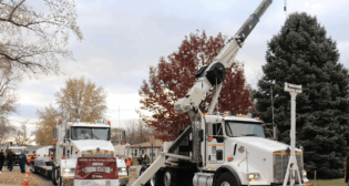 A Union Pacific boom truck and lowboy truck position to transport Omaha’s official Christmas Tree, a 5,500-pound blue spruce donated from the front yard of a metro-area home. (Courtesy of UP)
