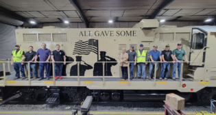 North Shore Railroad’s military veteran employees pictured with the company’s Veterans Unit, LVRR 9052. The locomotive was dedicated to this group, and each person signed an interior board that was sealed to remain on permanent display. (NSR Photograph, Courtesy of ASLRRA)